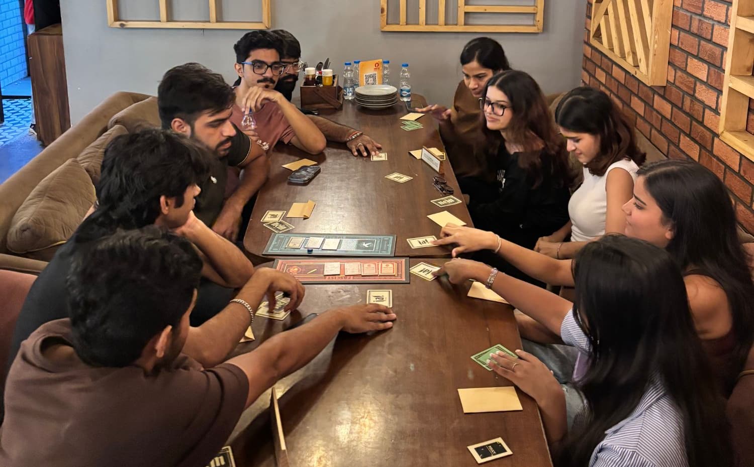 A SyncTrip game night: ten new friends playing Secret Hitler at a café