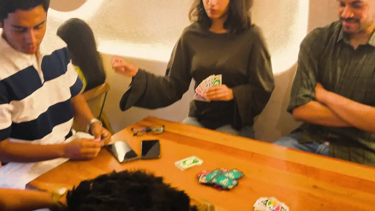 A SyncTrip board-game night: a full table of new friends